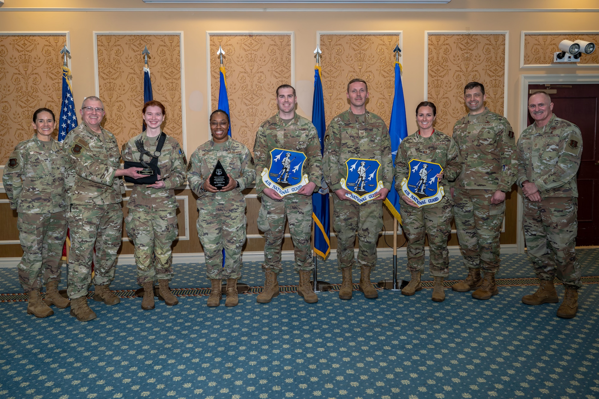 Group of 9 Airmen with center 5 holding various awards