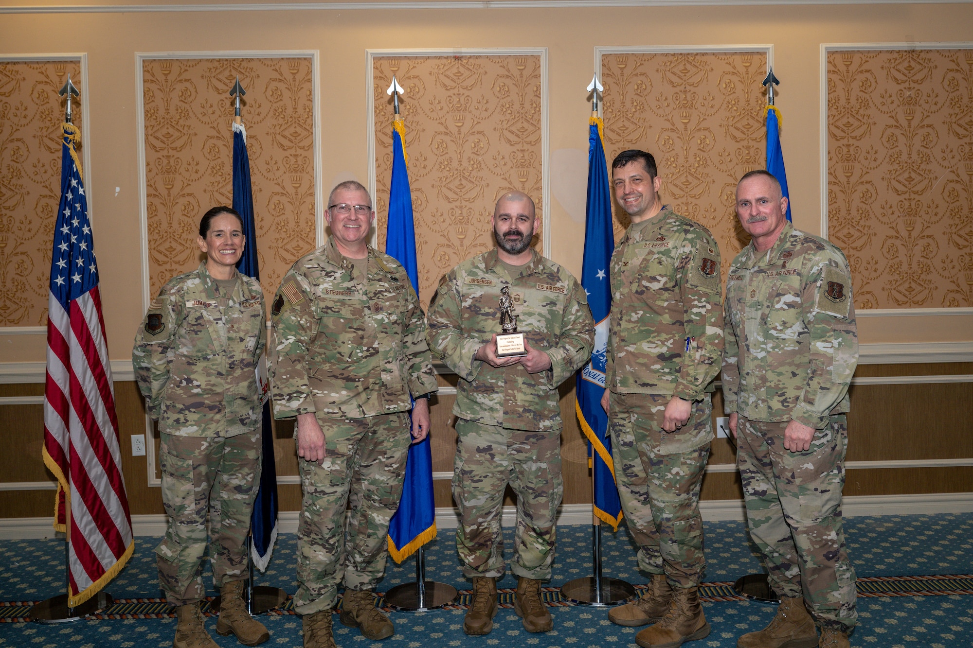 Group of 5 Airmen with center holding Outstanding Noncommissioned Officer of the Year Award