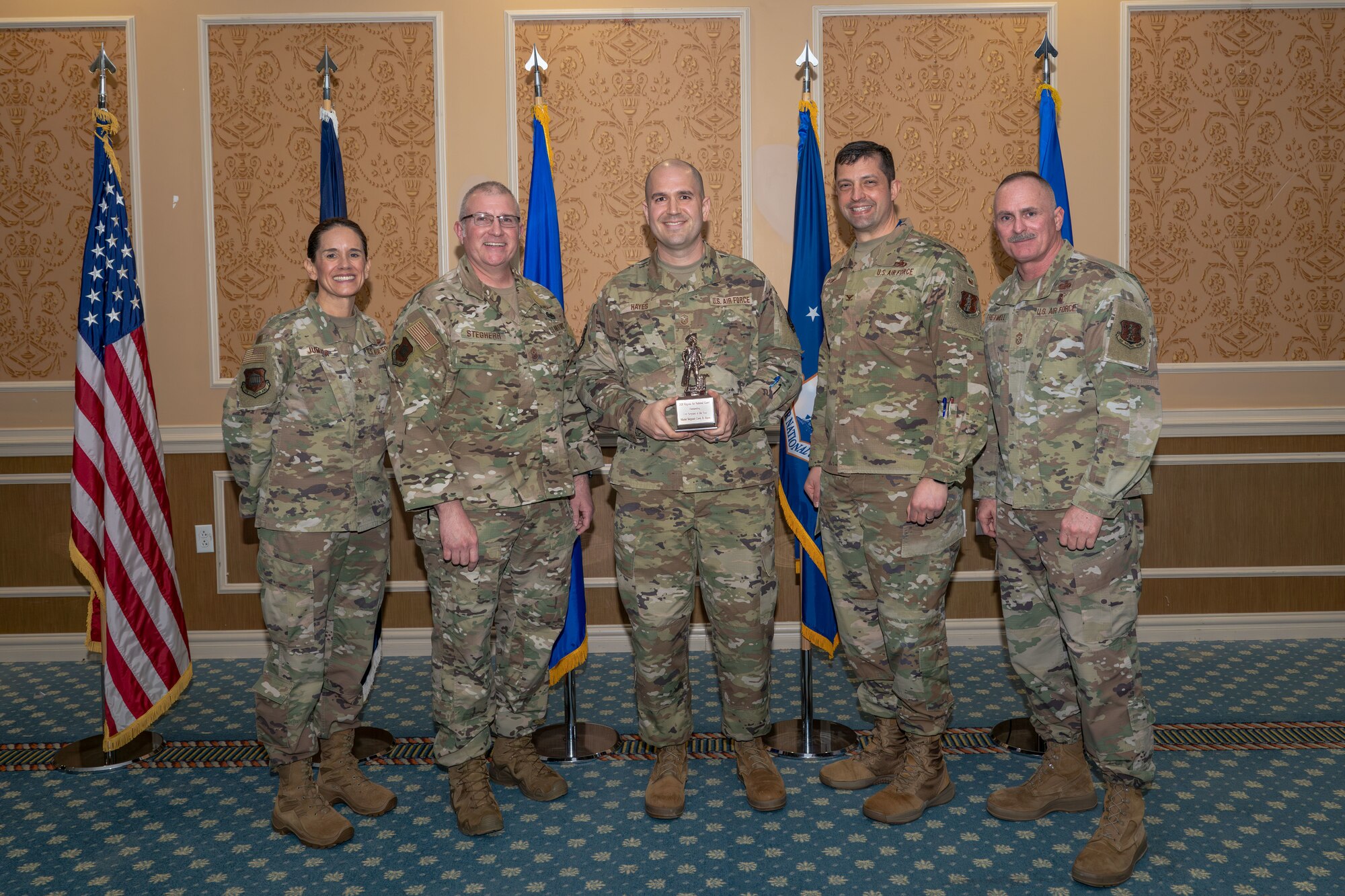 Group of 5 Airmen with center holding Outstanding First Sergeant of the Year Award