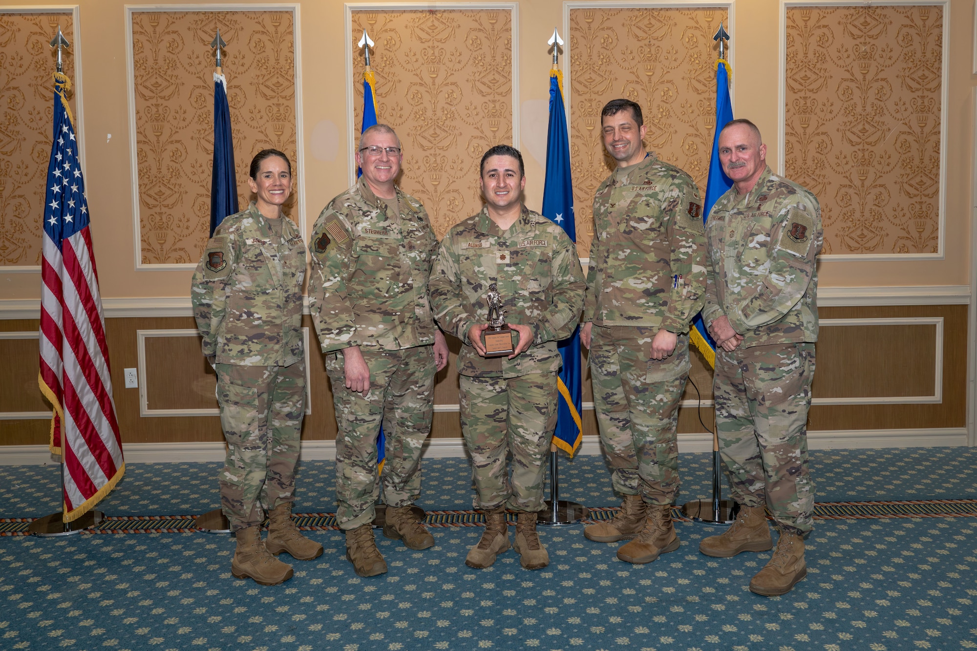 Group of 5 Airmen with center holding Outstanding Company Grade Officer of the Year Award.