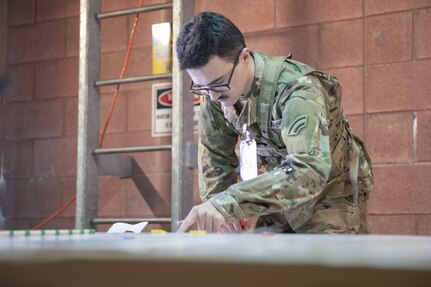 New York Army National Guard Soldier Pfc. Nolan Semprivivo, assigned to the Main Command Post-Operational Detachment, 42nd Infantry Division, reviews map calculations Jan. 29, 2025, at Fort Indiantown Gap, Pa. The Soldiers’ participation in the division’s Warfighter exercise ensures the unit maintains readiness and proficiency in their respective military occupational specialties. (U.S. Army photo by Sgt. Grace Nechanicky)