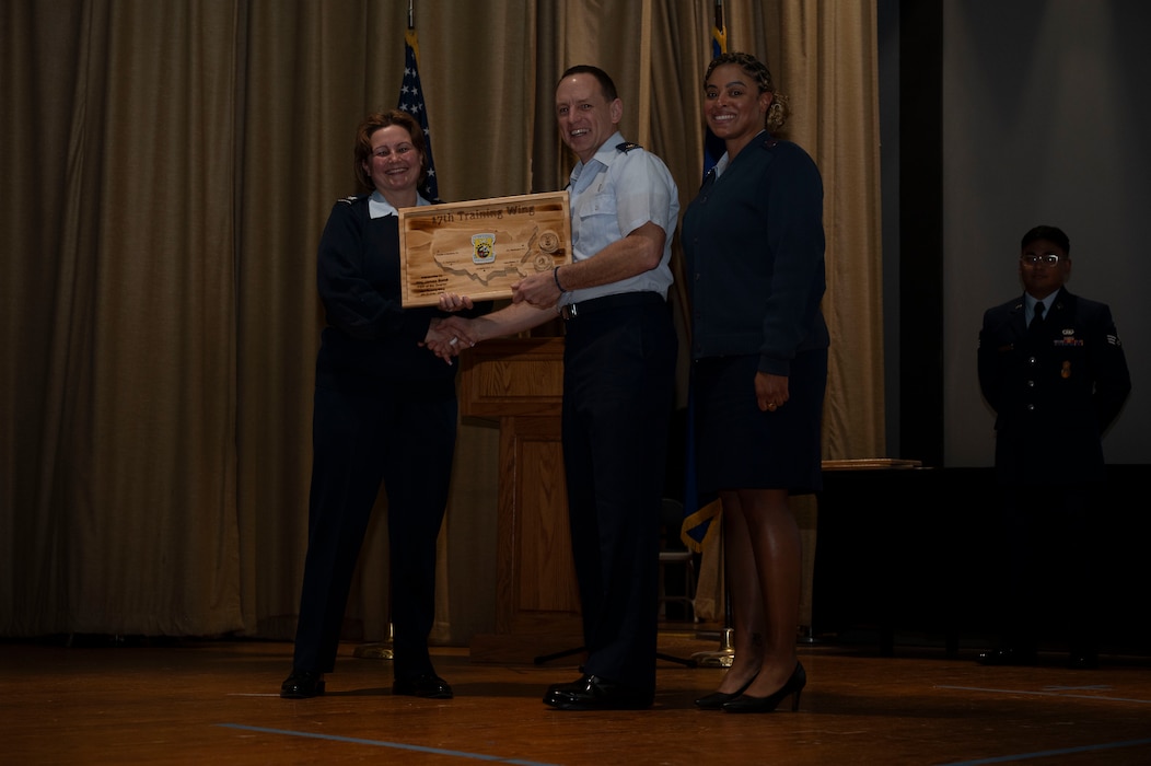 U.S. Air Force Col. Angelina Maguinness, 17th Training Wing commander, and Chief Master Sgt. Khamillia A. Washington, 17th TRW command chief, present Maj. James Bond, 17th Wing Staff Agencies with the Field Grade Officer of the Quarter award at the base theater, Goodfellow Air Force Base, Texas, Feb. 7, 2025. Before the ceremony, Maguinness and Washington took the floor for the Commander’s All-Call. (U.S. Air Force photo by Senior Airman Sarah Williams)