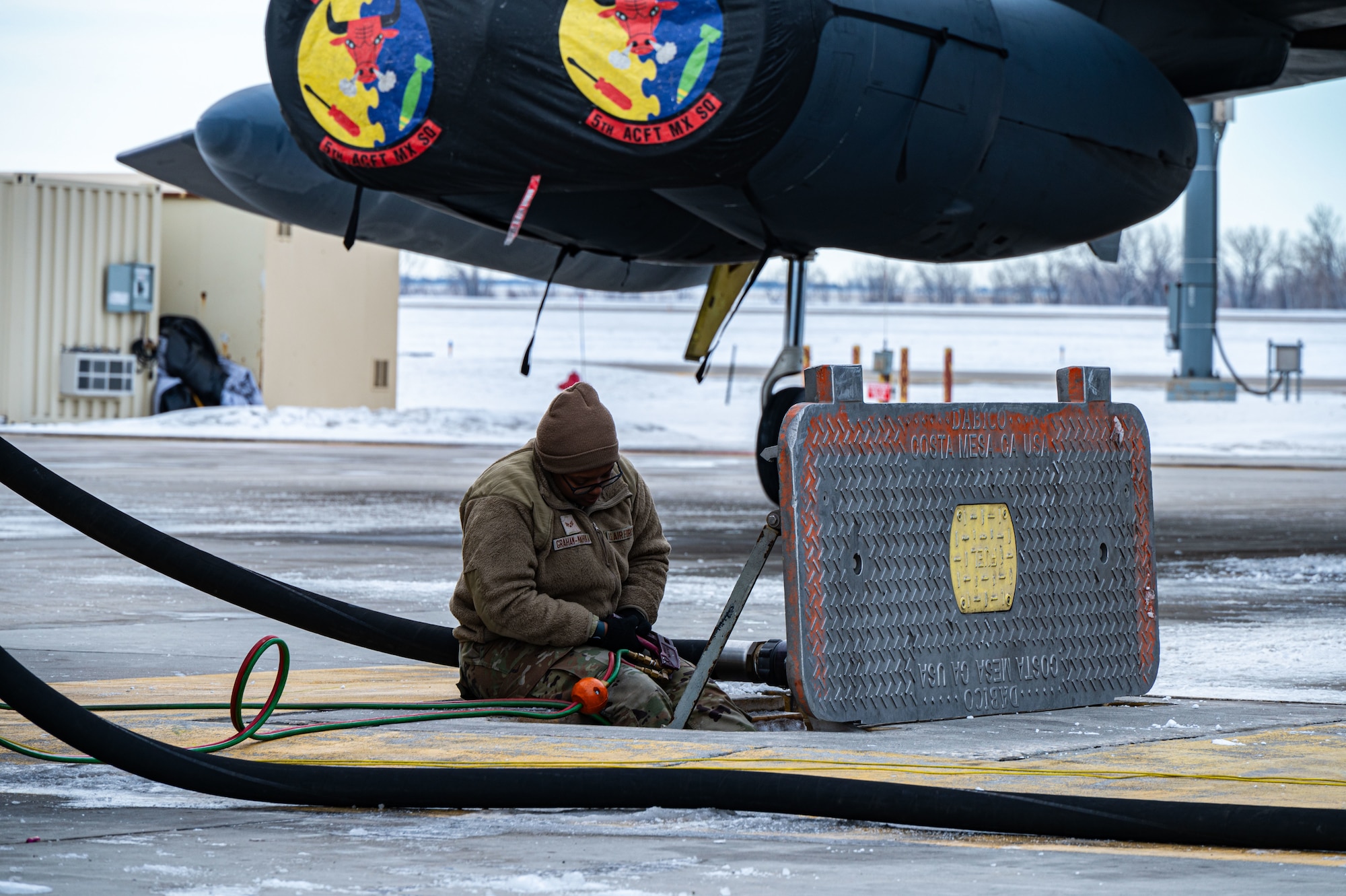 Senior Airman Nichelle Graham-Mahuka, a 5th Logistic Readiness Squadron fuels distribution operator, delivers fuel to an aircraft at Minot Air Force Base, North Dakota, Jan. 29, 2025. Petroleum, oil and lubricant distribution operators manage  refueling trucks to supply fuel to aircraft. (U.S. Air Force photo by Airman 1st Class Padilla)