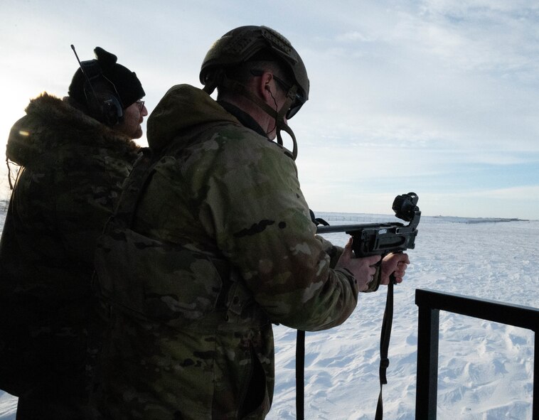 Tech. Sgt. Neal Baker, 91st Missile Security Operations Squadron defender, fires an M320A1 Grenade Launcher with the help of alternate gunner U.S. Air Force Staff Sgt. Christopher Charbonneau, 5th Security Forces Squadron combat arms section instructor, at Minot Air Force Base, North Dakota, Jan. 30, 2025. An alternate gunner is used when firing the M320A1 Grenade Launcher to help the shooter reload by passing over rounds and giving aiming adjustments. (U.S. Air Force photo by Airman 1st Class Wesley Davies)