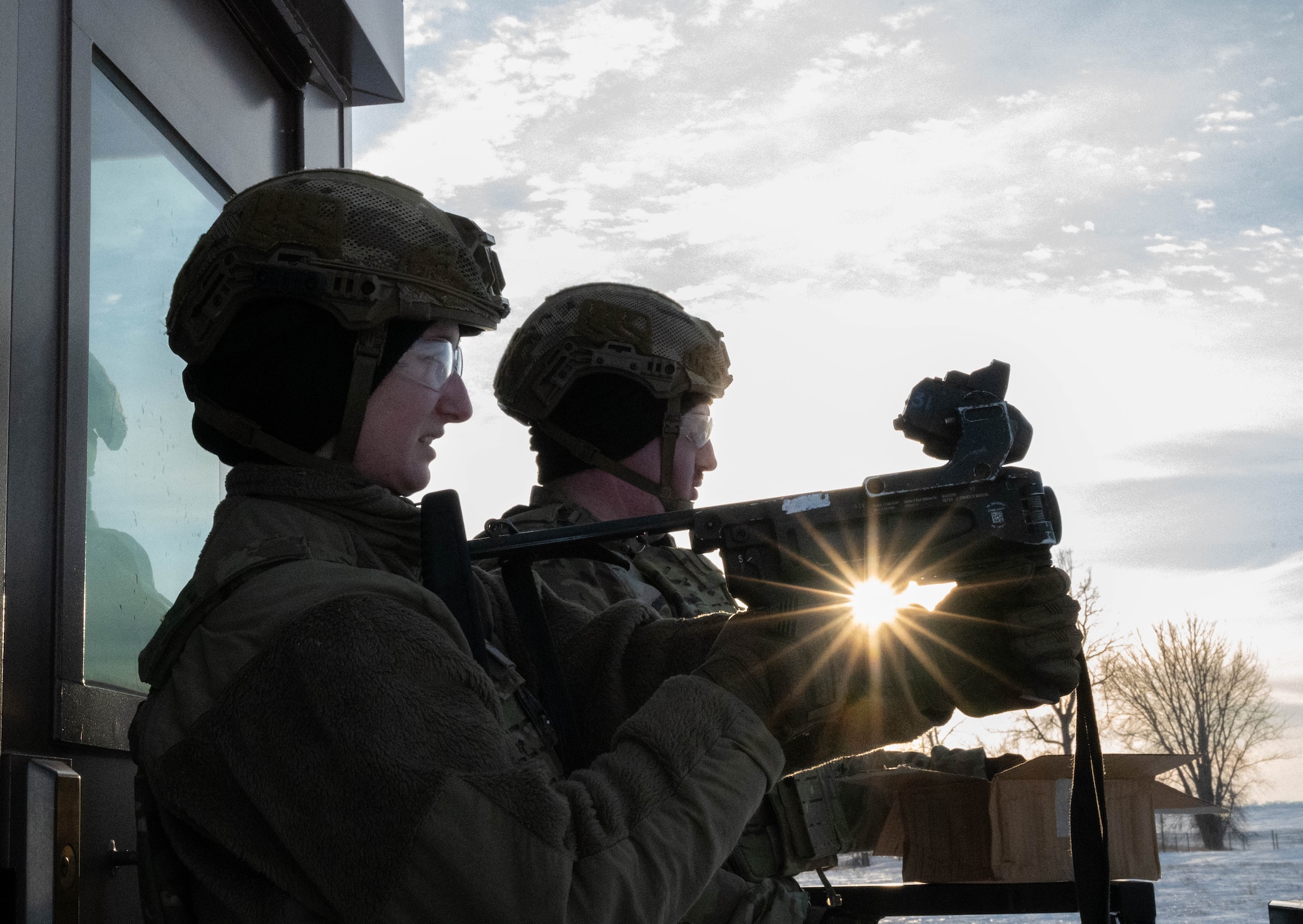 Airman Paridy Seng, 5th Security Forces Squadron defender, shoots an M320A1 Grenade Launcher with the help of alternate gunner Airman 1st Class Isaac Mann, 5SFS defender, at Minot Air Force Base, North Dakota, Jan. 30, 2025. An alternate gunner is used when firing the M320A1 Grenade Launcher to help the shooter reload by passing over rounds and giving aiming adjustments. (U.S. Air Force photo by Airman 1st Class Wesley Davies)