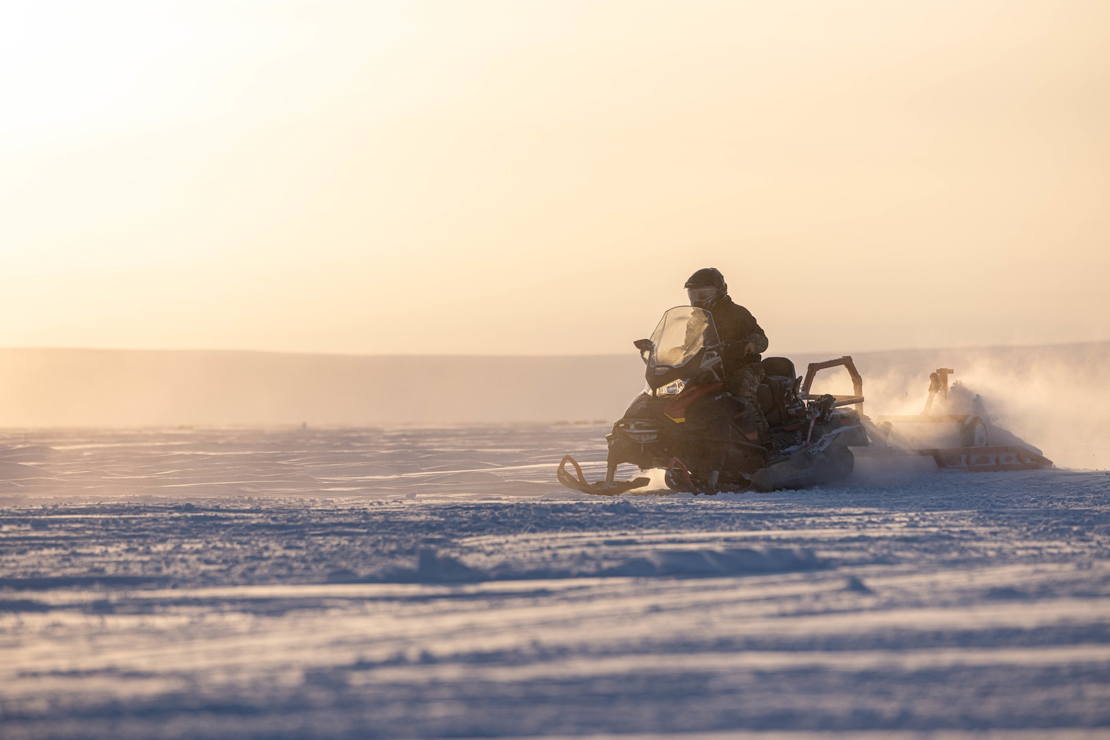 U.S. Air Force Tech. Sgt. Matthew Gadway, a member of the 109th Airlift Wing’s Polar Camp Skiway Team, grooms a ski landing area with a snow machine at Templeton Bay, Nunavut, Canada, March 13, 2023. The 109th’s LC-130's landed on the ski landing area to transport personnel and cargo to the austere Arctic environment during exercise Guerrier Nordique 2023.