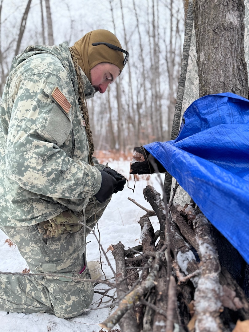 An Air National Guard Airmen helps build a thermal shelter using limited supplies and materials found in nature during the Air National Guard's Cold Weather Operations Course at Camp Ripley Training Center, Minn., Feb. 4, 2025.