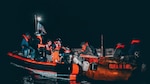 Crew members from U.S. Coast Guard Cutter Manowar distributing personal flotation devices to Cuban aliens on board a 25-foot makeshift vessel, 15 miles southwest of Gun Cay, Bahamas, Feb. 7, 2025. A total of 16 Cuban aliens were interdicted and repatriated. (U.S. Coast Guard photo)