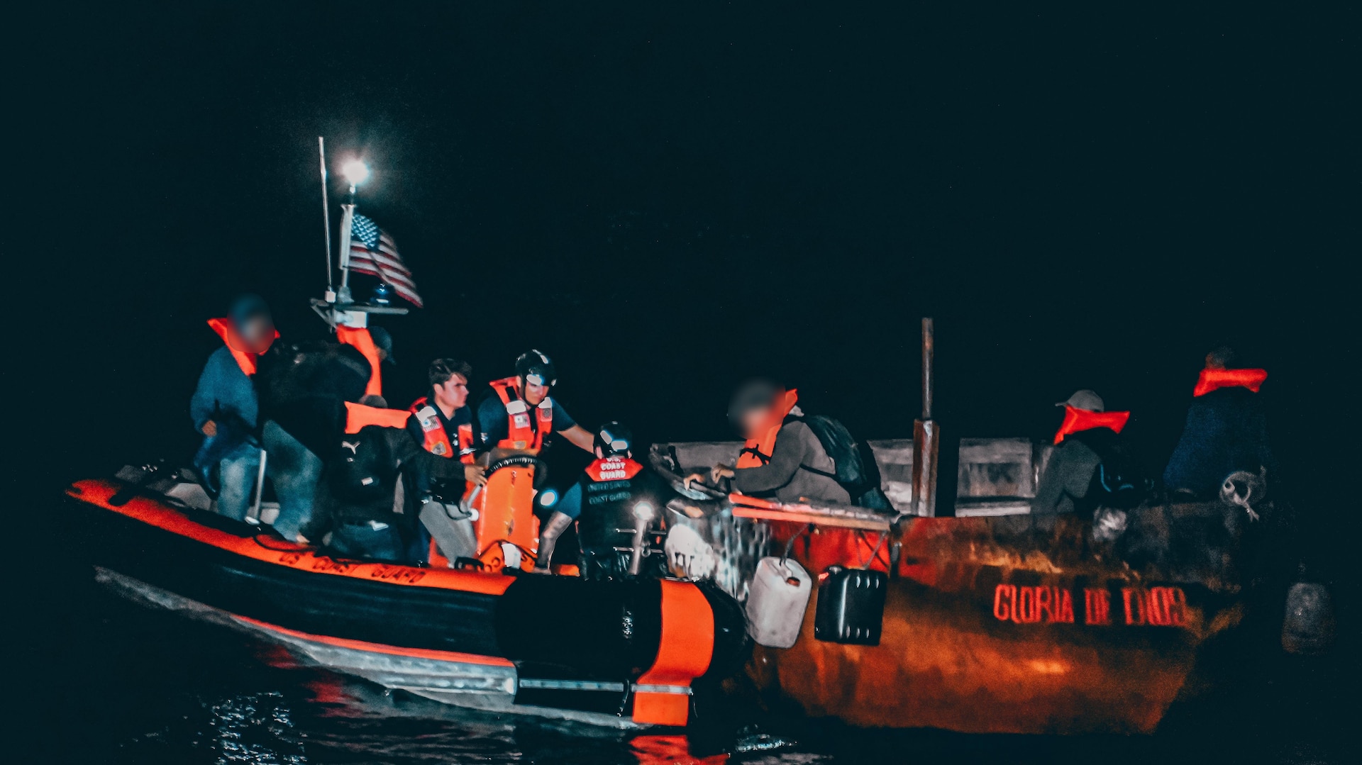 Crew members from U.S. Coast Guard Cutter Manowar distributing personal flotation devices to Cuban aliens on board a 25-foot makeshift vessel, 15 miles southwest of Gun Cay, Bahamas, Feb. 7, 2025. A total of 16 Cuban aliens were interdicted and repatriated. (U.S. Coast Guard photo)