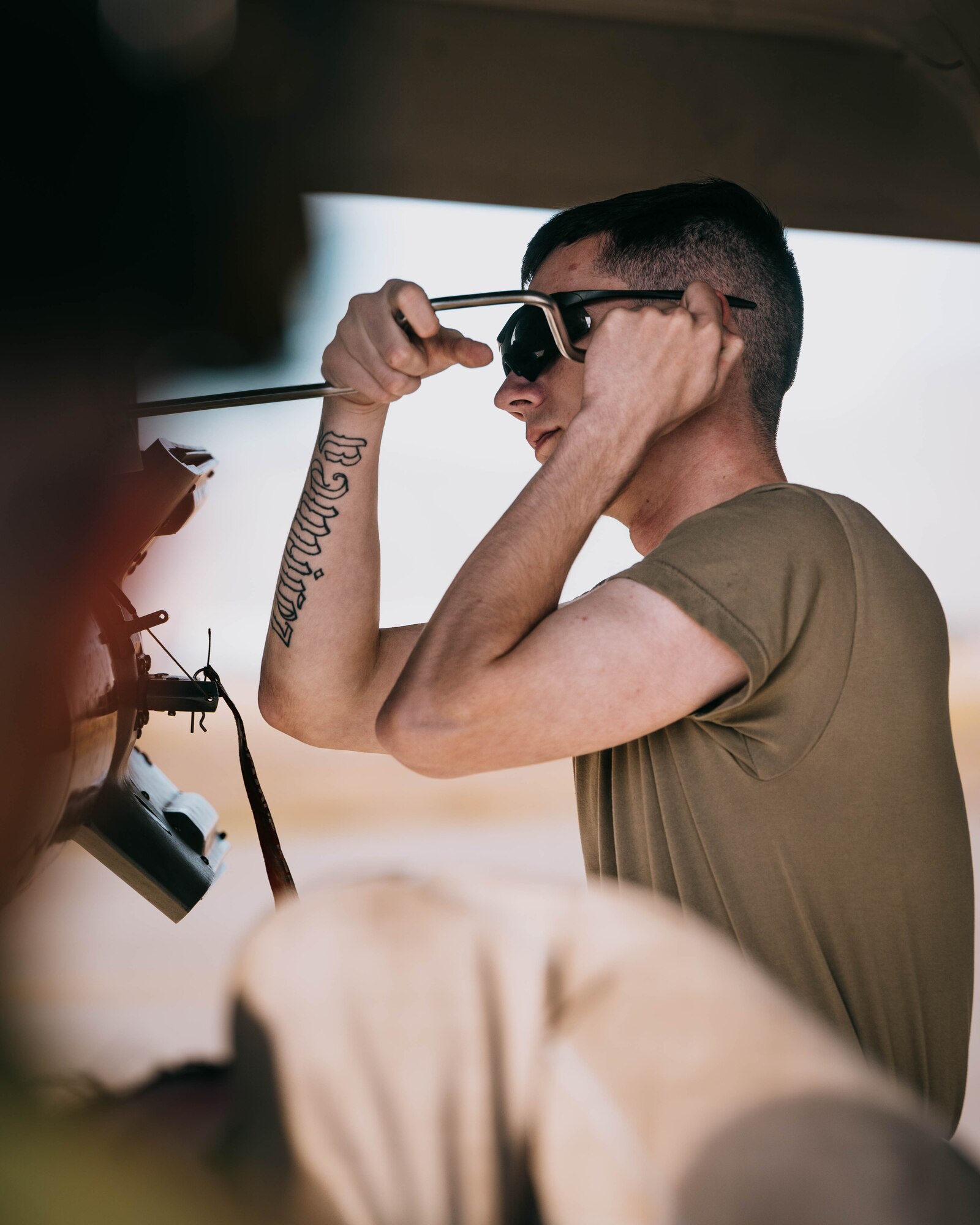 U.S. Air Force Airman 1st Class Gabriel Raanes, 310th Aircraft Maintenance Unit weapons load crew member secures a bomb rack panel by screwing fasteners in.