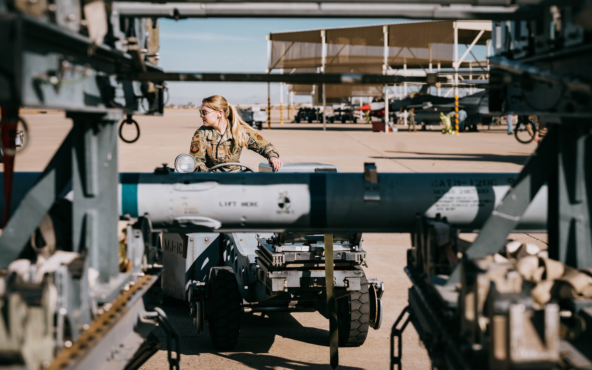 U.S. Air Force Senior Airman Mayson Brinckerhoff, 61st Aircraft Maintenance Unit weapons sterilization crew member, navigates a jammer to reload ammunition.