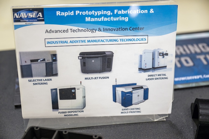 A sign highlights photos of various 3D printing machines.