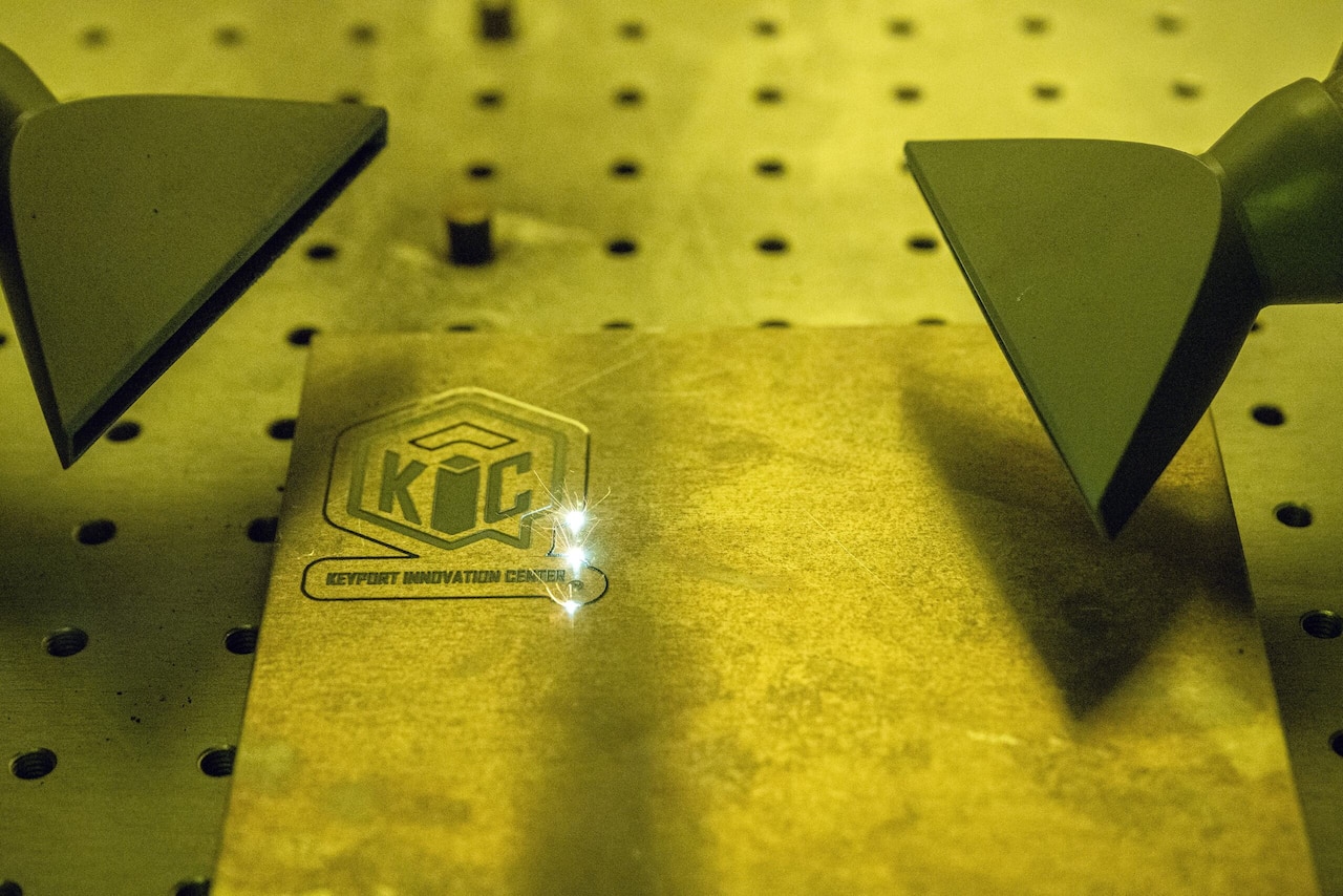 A laser engraver cuts an emblem into steel.