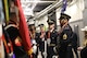 Service members in ceremonial uniforms are talking in a hallway at Caesars Superdome just before they present the colors on the field for the Super Bowl.