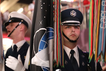 A Space Force Guardian is standing holding the Space Force flag as he waits to present the colors at Super Bowl LIX.