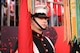 A Marine is standing on the sidelines at Super Bowl LIX holding a flag, waiting to present the colors on the field.