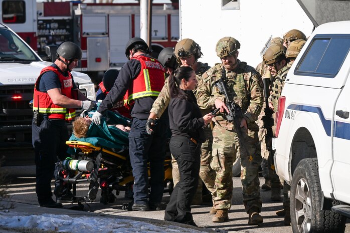 A group of 1st responders gather around a wounded actor
