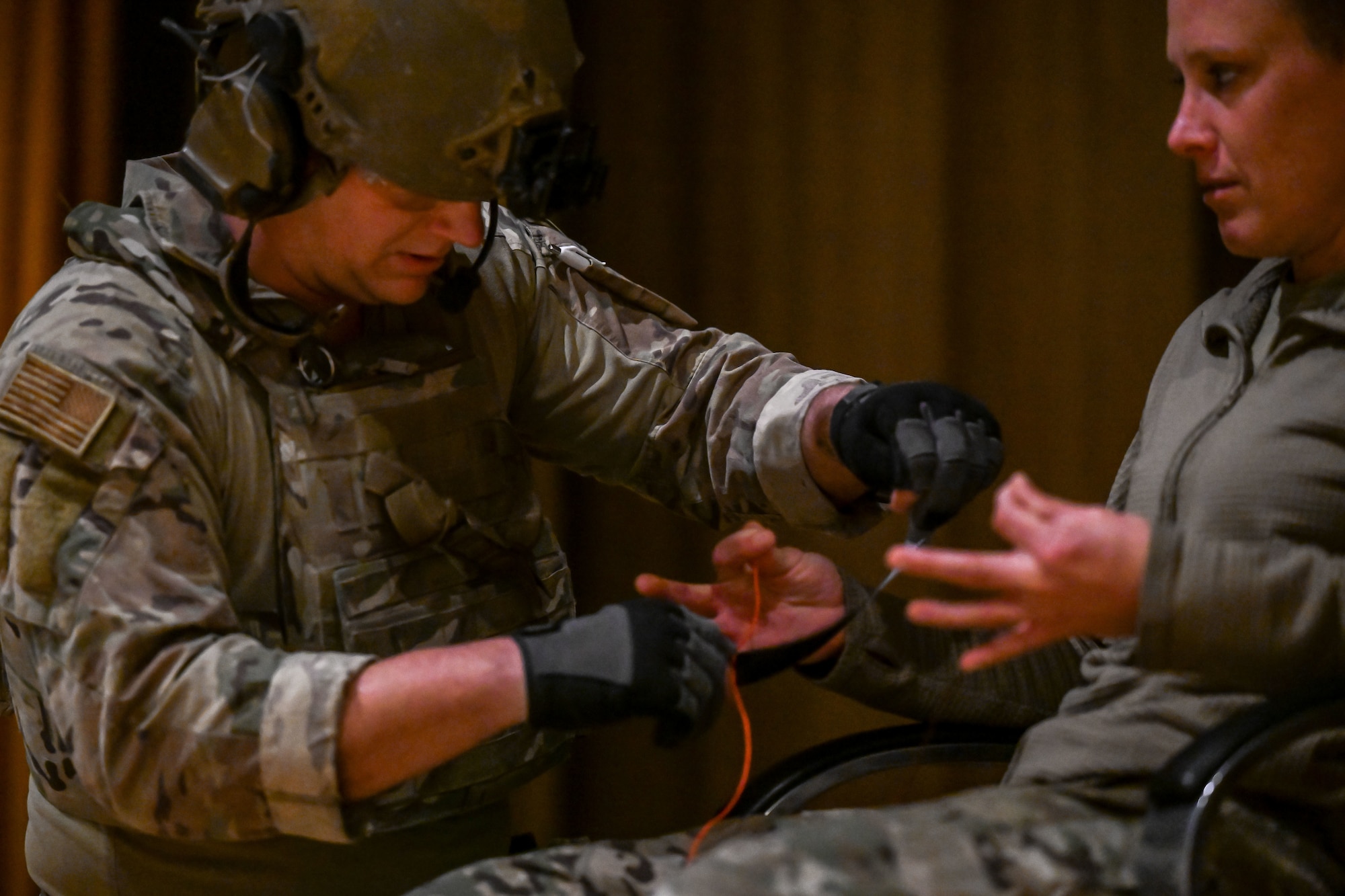 An airman tapes explosive wires to another airman acting as an hostage