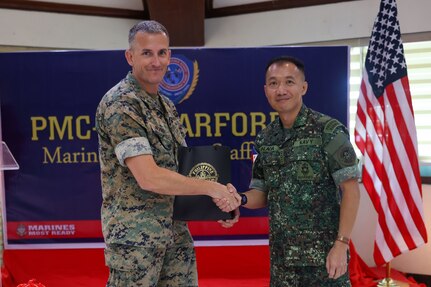 U.S. Marine Corps Col. Christopher Winn, left, assistant chief of staff, G-5 Plans Division, U.S. Marine Corps Forces, Pacific, and Philippine Marine Corps Col. Enstein B. Calaoa, Chief of Marine Staff, PMC, exchange gifts after the 2025 PMC-MARFORPAC Marine-to-Marine Staff Talks, Fort Bonifacio, Philippines, Feb. 6, 2025.