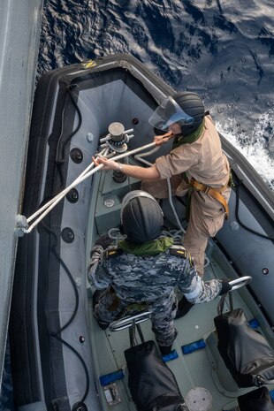 SOUTH CHINA SEA (Feb. 6, 2025) Lt. j. g. Peter Greenbaum, assigned to the Arleigh Burke-class guided-missile destroyer USS Benfold (DDG 65), and Australian Navy Sailors rig a Zodiac Mark 2 Grand Raider general purpose inflatable boat alongside USS Benfold during multilateral operations with Australia and the United Kingdom in the South China Sea, Feb. 6. Benfold is forward deployed and assigned to Destroyer Squadron (DESRON) 15, the Navy’s Largest DESRON and U.S. 7th Fleet’s principal surface force. (U.S. Navy Photo by Mass Communication Specialist 2nd Class Monica Walker.)
