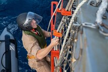 SOUTH CHINA SEA (Feb. 6, 2025) Lt. j. g. Peter Greenbaum, a junior officer stationed aboard the Arleigh Burke-class guided-missile destroyer USS Benfold (DDG 65), climbs a ladder up the starboard side of USS Benfold during multilateral operations with Australia and the United Kingdom in the South China Sea, Feb. 6. Benfold is forward deployed and assigned to Destroyer Squadron (DESRON) 15, the Navy’s Largest DESRON and U.S. 7th Fleet’s principal surface force. (U.S. Navy Photo by Mass Communication Specialist 2nd Class Monica Walker.)