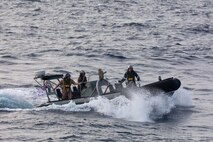 SOUTH CHINA SEA (Feb. 6, 2025) Lt. j. g. Peter Greenbaum, assigned to the Arleigh Burke-class guided-missile destroyer USS Benfold (DDG 65), and Australian Navy Sailors guide a Zodiac Mark 2 Grand Raider general purpose inflatable boat toward USS Benfold during multilateral operations with Australia and the United Kingdom in the South China Sea, Feb. 6. Benfold is forward deployed and assigned to Destroyer Squadron (DESRON) 15, the Navy’s Largest DESRON and U.S. 7th Fleet’s principal surface force. (U.S. Navy Photo by Mass Communication Specialist 2nd Class Monica Walker.)