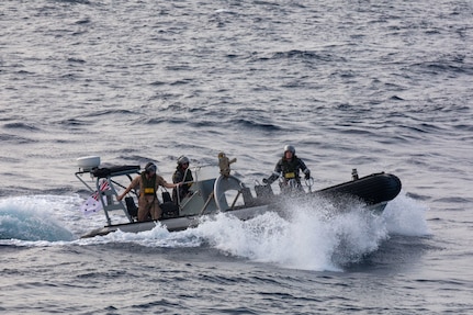 SOUTH CHINA SEA (Feb. 6, 2025) Lt. j. g. Peter Greenbaum, assigned to the Arleigh Burke-class guided-missile destroyer USS Benfold (DDG 65), and Australian Navy Sailors guide a Zodiac Mark 2 Grand Raider general purpose inflatable boat toward USS Benfold during multilateral operations with Australia and the United Kingdom in the South China Sea, Feb. 6. Benfold is forward deployed and assigned to Destroyer Squadron (DESRON) 15, the Navy’s Largest DESRON and U.S. 7th Fleet’s principal surface force. (U.S. Navy Photo by Mass Communication Specialist 2nd Class Monica Walker.)