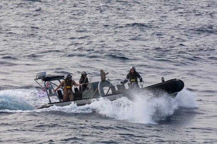 SOUTH CHINA SEA (Feb. 6, 2025) Lt. j. g. Peter Greenbaum, assigned to the Arleigh Burke-class guided-missile destroyer USS Benfold (DDG 65), and Australian Navy Sailors guide a Zodiac Mark 2 Grand Raider general purpose inflatable boat toward USS Benfold during multilateral operations with Australia and the United Kingdom in the South China Sea, Feb. 6. Benfold is forward deployed and assigned to Destroyer Squadron (DESRON) 15, the Navy’s Largest DESRON and U.S. 7th Fleet’s principal surface force. (U.S. Navy Photo by Mass Communication Specialist 2nd Class Monica Walker.)