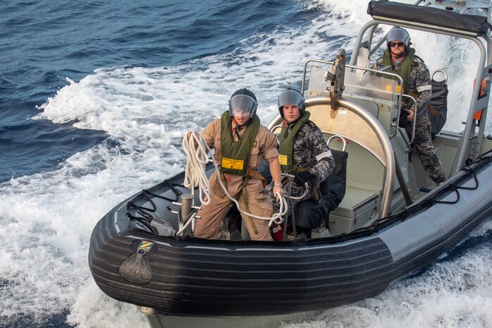 SOUTH CHINA SEA (Feb. 6, 2025) Lt. j. g. Peter Greenbaum, assigned to the Arleigh Burke-class guided-missile destroyer USS Benfold (DDG 65), and Australian Navy Sailors guide a Zodiac Mark 2 Grand Raider general purpose inflatable boat alongside USS Benfold during multilateral operations with Australia and the United Kingdom in the South China Sea, Feb. 6. Benfold is forward deployed and assigned to Destroyer Squadron (DESRON) 15, the Navy’s Largest DESRON and U.S. 7th Fleet’s principal surface force. (U.S. Navy Photo by Mass Communication Specialist 2nd Class Monica Walker.)