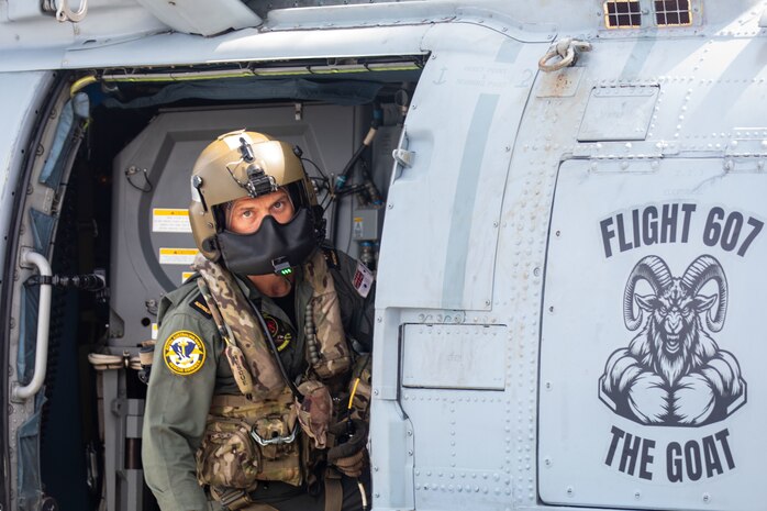 SOUTH CHINA SEA (Feb. 6, 2025) Royal Australian Navy Sailor Leading Seaman Edward Ploy leans out of an Royal Australian Navy MH-60R helicopter on the flight deck of the Arleigh Burke-class guided missile destroyer USS Benfold (DDG 65) during multilateral operations with Australia and the United Kingdom in the South China Sea, Feb. 6. Benfold is forward deployed and assigned to Destroyer Squadron (DESRON) 15, the Navy’s Largest DESRON and U.S. 7th Fleet’s principal surface force. (U.S. Navy Photo by Mass Communication Specialist 2nd Class Monica Walker.)