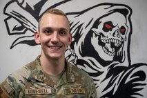 U.S. Air Force 2nd Lt. Nathan Lovewell, 35th Logistics Readiness Squadron (LRS) asset management officer in charge, poses for a photograph in front of a mural of the 35th LRS mascot.