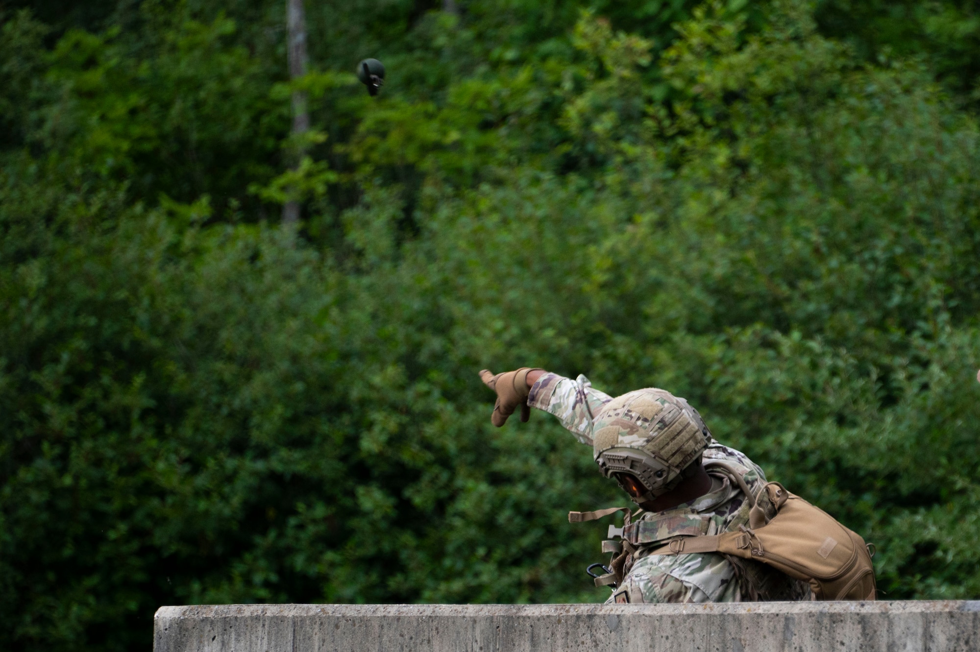 An Airman throws a hand grenade
