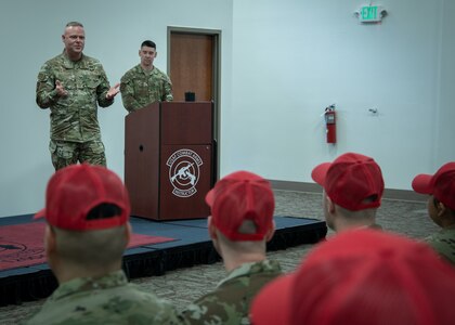 Gallagher stands on low stage and talks with audience