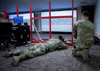 Carver in the prone position facing screen with scenario displays on screen