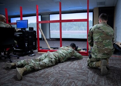 Carver in the prone position facing screen with scenario displays on screen