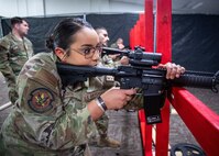 Alvardo leans into M18 weapon looking through scope