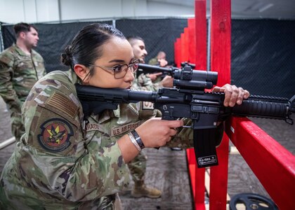 Alvardo leans into M18 weapon looking through scope