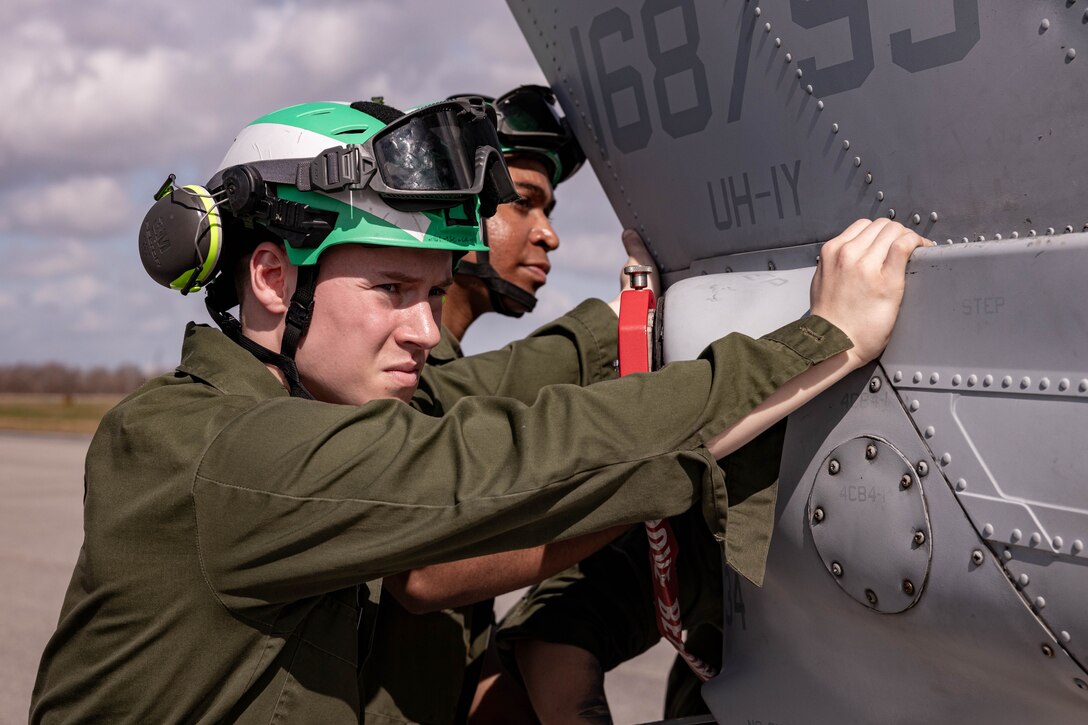 U.S. Marine Corps Cpl. Joseph Poeppelmeier, airframe technician prepares to load a UH-1Y Venom helicopter during a C-5 Super Galaxy aircraft static load exercise at Naval Air Station Joint Reserve Base New Orleans, Belle Chasse, Louisiana, Feb. 6, 2025. Poeppelmeier with Marine Light Attack Helicopter Squadron (HMLA) 773, 4th Marine Aircraft Wing, Marine Forces Reserve, trained alongside U.S. Airmen, 26th Aerial Port Squadron, 68th Airlift Squadron, to mentor and develop the next generation of logisticians, while fostering cross service knowledge and collaboration between Air Force and Marine Corps teams. (U.S. Marine Corps photo by Sgt. Emely Gonzalez)
