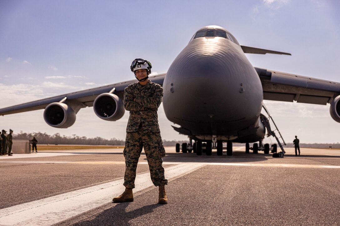 U.S. Marine Corps Cpl. Jose E. Lopez, logistics specialist poses for a photo during a C-5 Super Galaxy aircraft static load exercise at Naval Air Station Joint Reserve Base New Orleans, Belle Chasse, Louisiana, Feb. 6, 2025. Lopez with Marine Forces Reserves G-4, trained alongside Marine Light Attack Helicopter Squadron (HMLA) 773 and U.S. Airmen, 26th Aerial Port Squadron, 68th Airlift Squadron to mentor and develop the next generation of logisticians, while fostering cross service knowledge and collaboration between Air Force and Marine Corps teams. (U.S. Marine Corps photo by Sgt. Emely Gonzalez)
