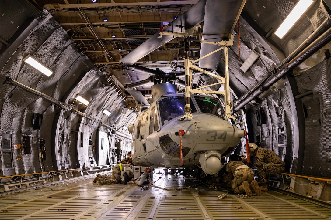U.S. Marines and U.S. Airmen secure a UH-1Y Venom helicopter onto a C-5 Super Galaxy during a static load exercise at Naval Air Station Joint Reserve Base New Orleans, Belle Chasse, Louisiana, Feb. 6, 2025. Marine Light Attack Helicopter Squadron (HMLA) 773, 4th Marine Aircraft Wing, Marine Forces Reserve, trained alongside U.S. Airmen, 26th Aerial Port Squadron, 68th Airlift Squadron, to mentor and develop the next generation of logisticians, while fostering cross service knowledge and collaboration between Air Force and Marine Corps teams. (U.S. Marine Corps photo by Sgt. Emely Gonzalez)