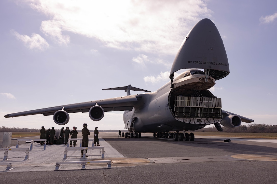 U.S. Airmen prepare to drop the loading dock of a C-5 Super Galaxy aircraft during a static load exercise at Naval Air Station Joint Reserve Base New Orleans, Belle Chasse, Louisiana, Feb. 6, 2025. Marines with Marine Light Attack Helicopter Squadron (HMLA) 773, 4th Marine Aircraft Wing, Marine Forces Reserve, trained alongside U.S. Airmen, 26th Aerial Port Squadron, 68th Airlift Squadron, to mentor and develop the next generation of logisticians, while fostering cross service knowledge and collaboration between Air Force and Marine Corps teams. (U.S. Marine Corps photo by Sgt. Emely Gonzalez)