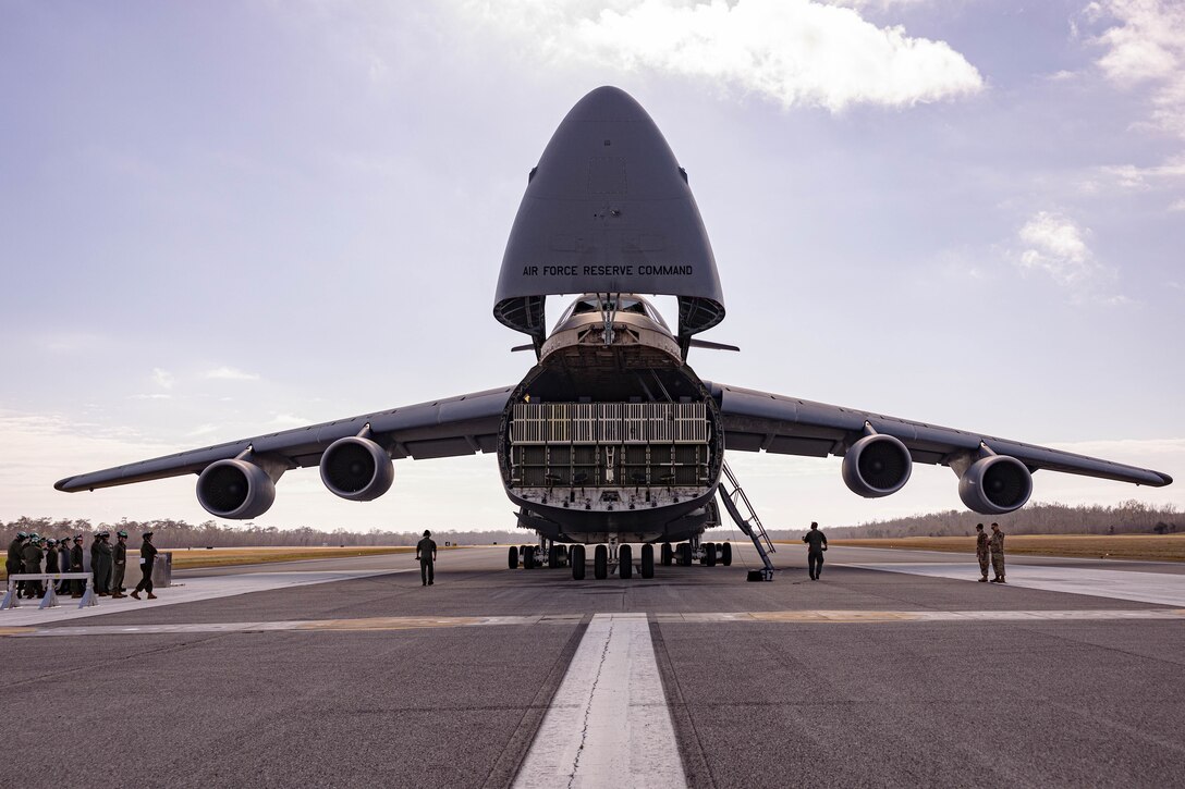 U.S. Airmen prepare to drop the loading dock of a C-5 Super Galaxy aircraft during a static load exercise at Naval Air Station Joint Reserve Base New Orleans, Belle Chasse, Louisiana, Feb. 6, 2025. Marine Light Attack Helicopter Squadron (HMLA) 773, 4th Marine Aircraft Wing, Marine Forces Reserve, trained alongside U.S. Airmen, 26th Aerial Port Squadron, 68th Airlift Squadron, to mentor and develop the next generation of logisticians, while fostering cross service knowledge and collaboration between Air Force and Marine Corps teams. (U.S. Marine Corps photo by Sgt. Emely Gonzalez)