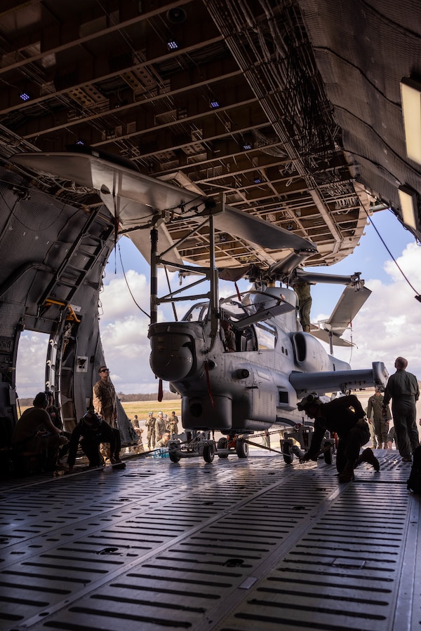 U.S. Marines and U.S. Airmen load an AH-1Z Viper helicopter onto a C-5 Super Galaxy aircraft during a static load exercise at Naval Air Station Joint Reserve Base New Orleans, Belle Chasse, Louisiana, Feb. 6, 2025. Marine Light Attack Helicopter Squadron (HMLA) 773, 4th Marine Aircraft Wing, Marine Forces Reserve, trained alongside U.S. Airmen, 26th Aerial Port Squadron, 68th Airlift Squadron, to mentor and develop the next generation of logisticians, while fostering cross service knowledge and collaboration between Air Force and Marine Corps teams. (U.S. Marine Corps photo by Sgt. Emely Gonzalez)