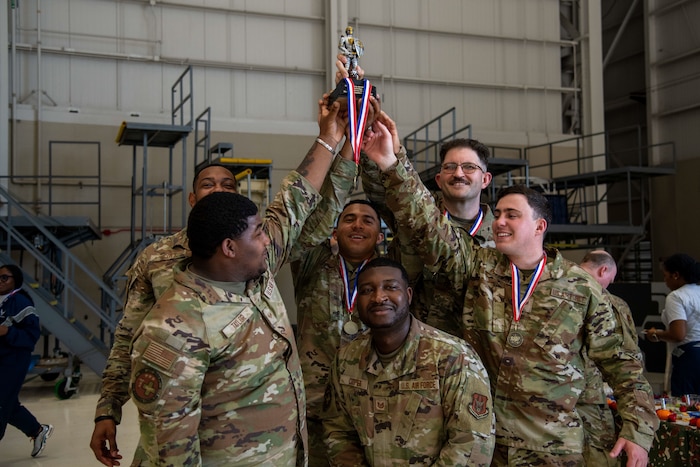 Airmen hold winners trophy from warrior challenge.