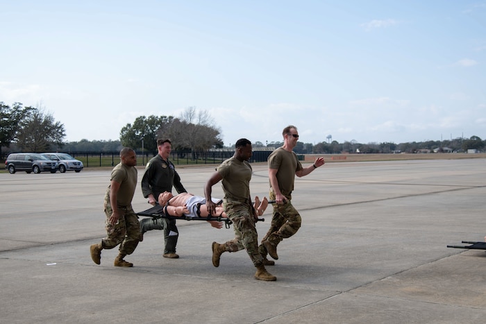 Four Airmen carry a litter during the warrior challenge.