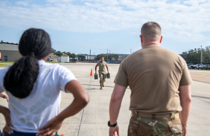 Airman carrying heavy weights during warrior challenge.