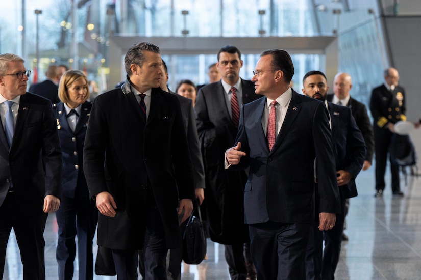 Two men in business suits are walking and talking.