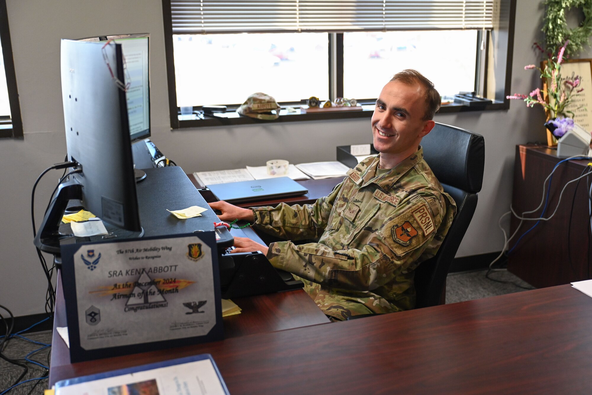 Senior Airman Kent Abbott, 97th Force Support Squadron Military Personnel Flight apprentice, sits at his desk at Altus Air Force Base, Oklahoma, Jan. 23, 2025. As a personnel specialist, Abbott manages Airmen’s retention, assignments, separations, and retirements. (U.S. Air Force photo by Airman 1st Class Jonah Bliss)