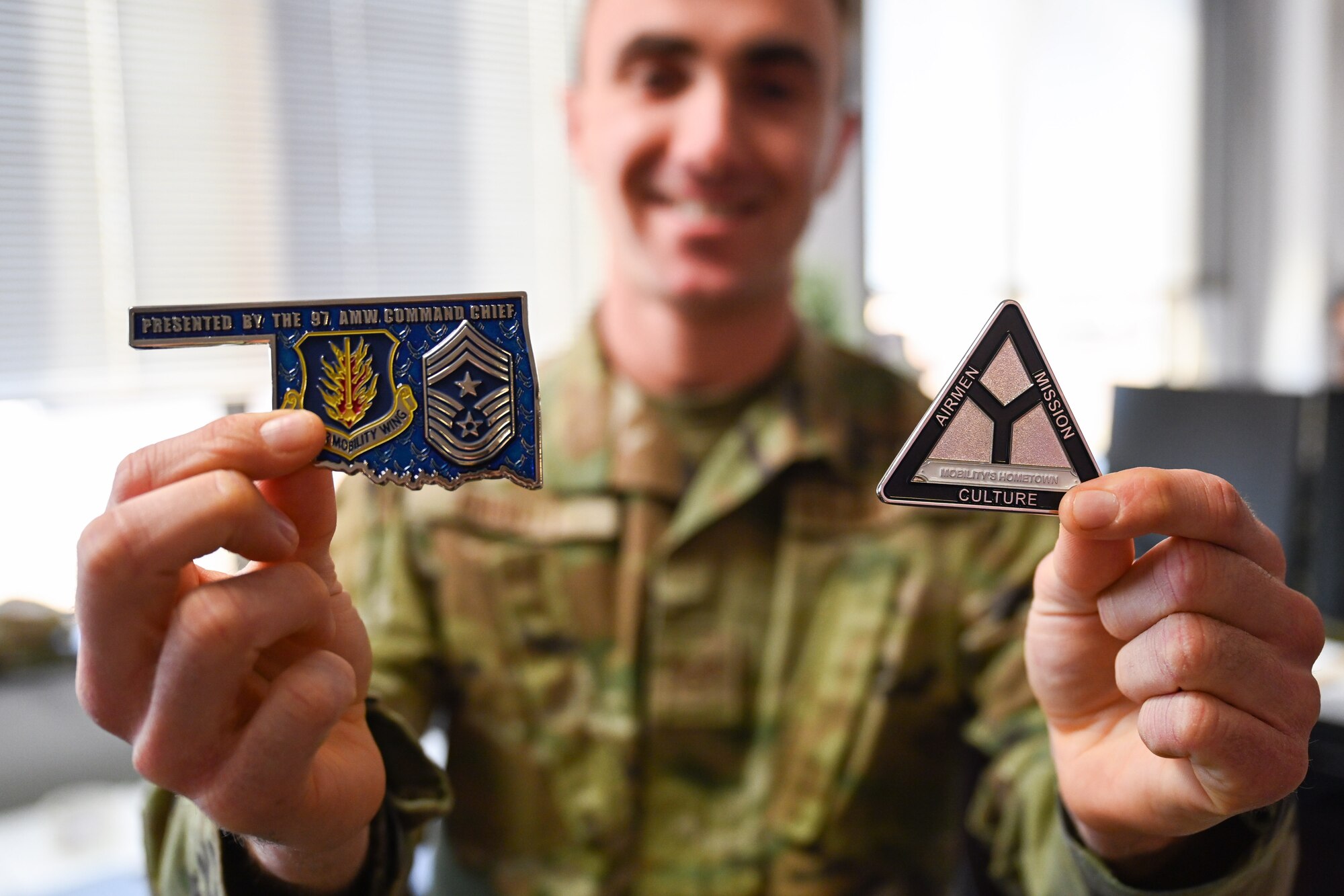 Senior Airman Kent Abbott, 97th Force Support Squadron Military Personnel Flight apprentice, poses for a photo with coins awarded to him at Altus Air Force Base, Oklahoma, Jan. 23, 2025. Abbott joined the Air Force to serve, learn, and give back. (U.S. Air Force photo by Airman 1st Class Jonah Bliss)