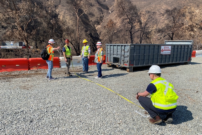 Geotechnical Branch engineers with the U.S. Army Corps of Engineers Los Angeles District advise Environmental Protection Agency representatives about relocating traffic barriers during a Feb. 10 technical assessment visit to the EPA’s wildfire debris removal transfer site near Topanga Canyon in Malibu, California. In addition to modeling predictions for debris flows for an impending rain event this week, hydraulic and geotechnical engineers physically assessed the site to advise EPA on measures to reduce potential risks from impending and future rainstorms.